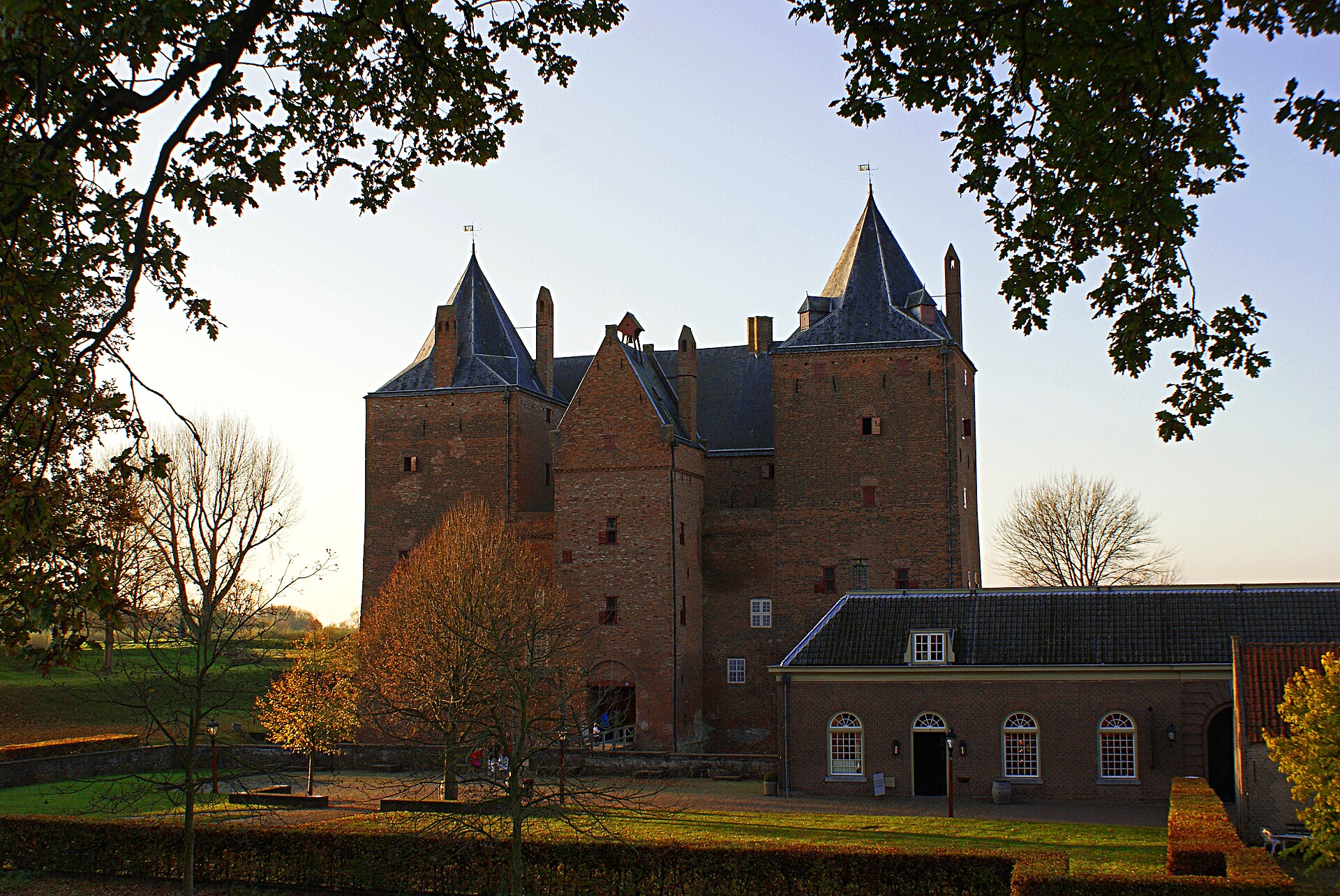 A historic brick castle stands surrounded by trees and a grassy courtyard, illustrating the enduring legacy of radio.