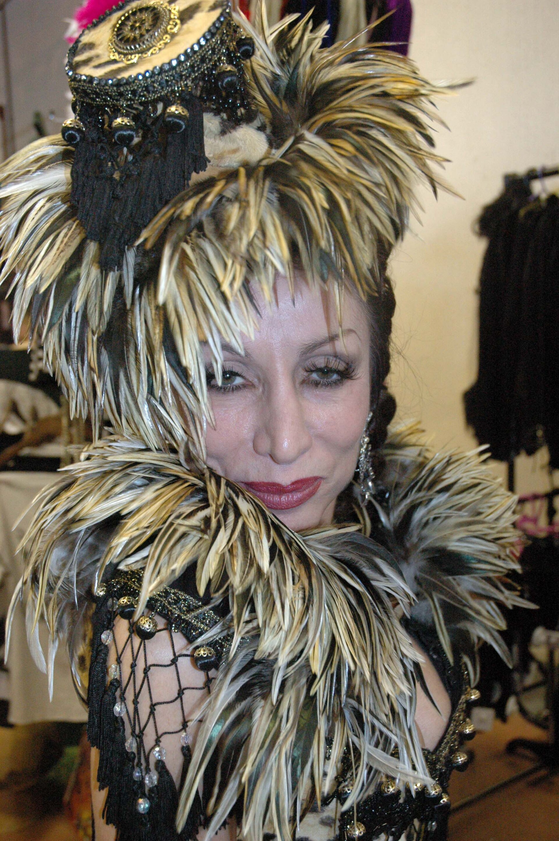 A woman in a feathered headdress and embellished costume embodies the drama of early radio performance.
